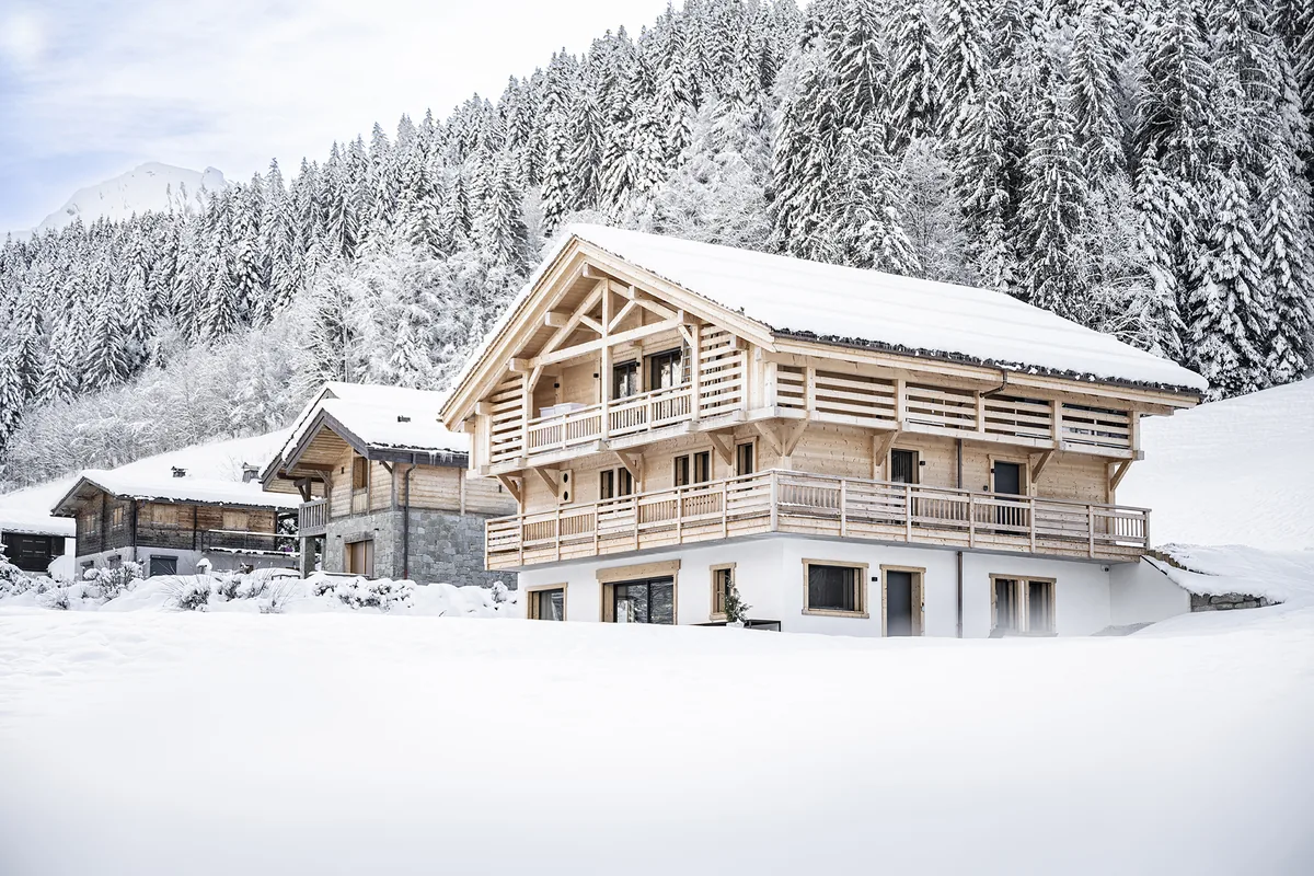 Le chalet Zenspace dans la neige, entouré de sapins, au Grand-Bornand