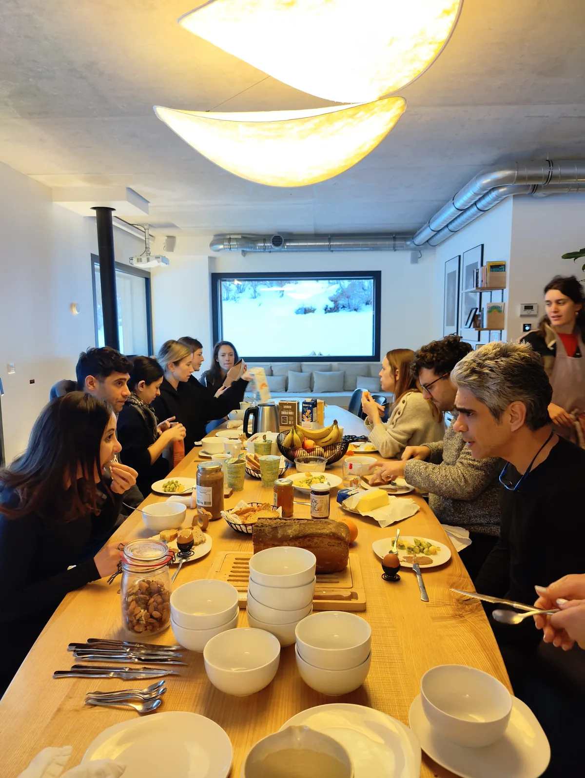 Les participant·es partagent un repas autour de la grande table