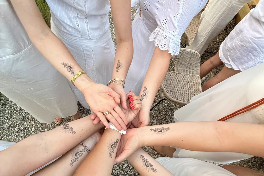 Mains parées d'or et d'argent lors de la soirée blanche d'une retraite de yoga Flowaway